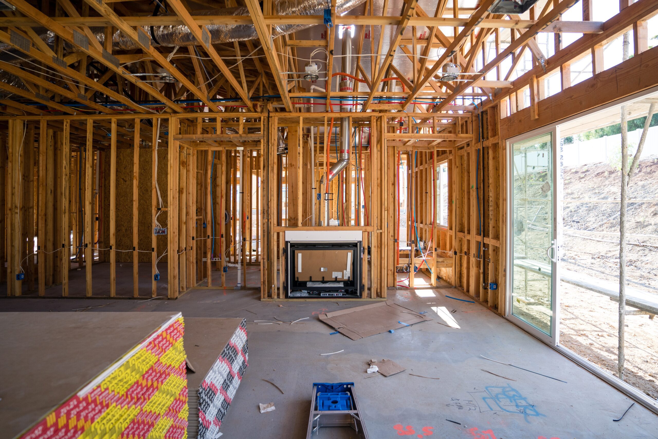 Framed new house under construction in Pensacola, showing wood structure and open layout.