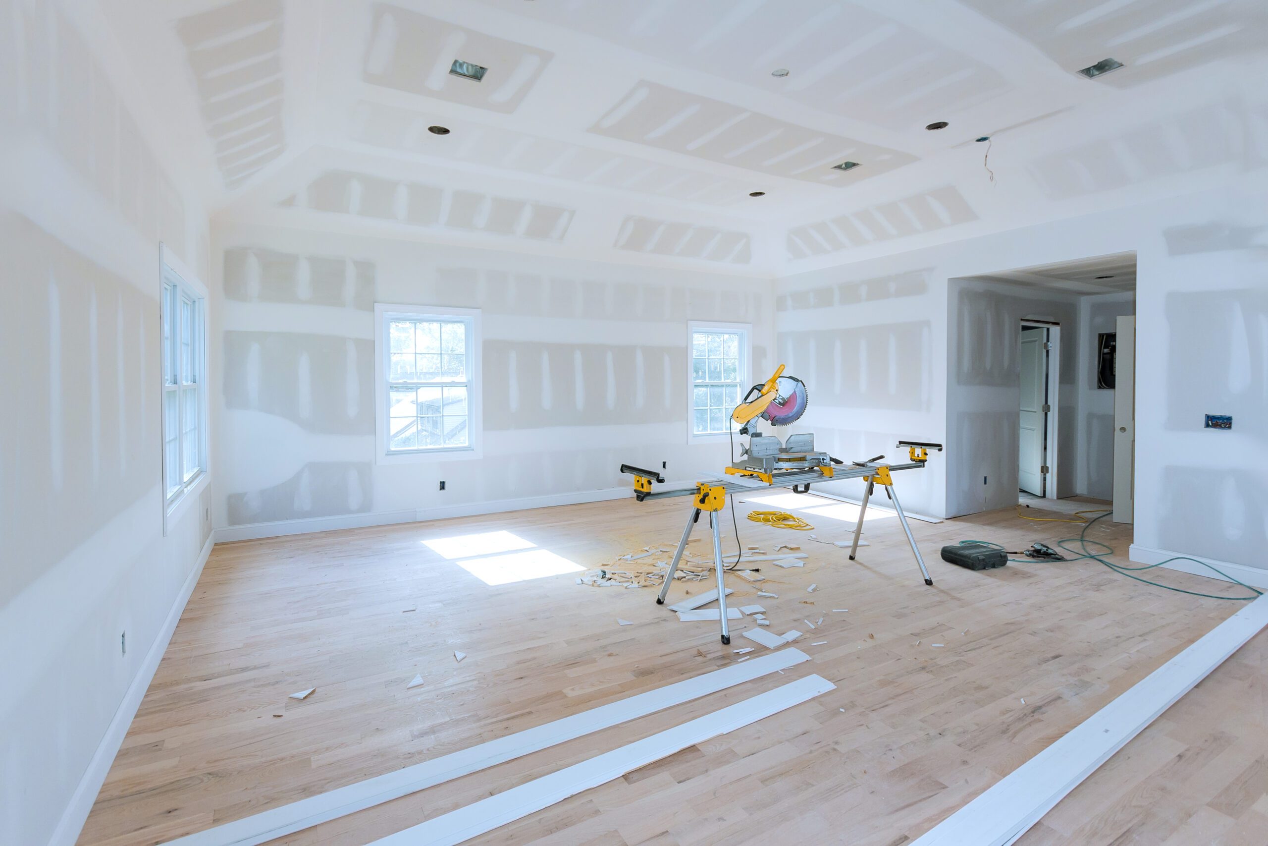 Spacious unfinished room with new drywall partially installed during a home renovation project in Pensacola